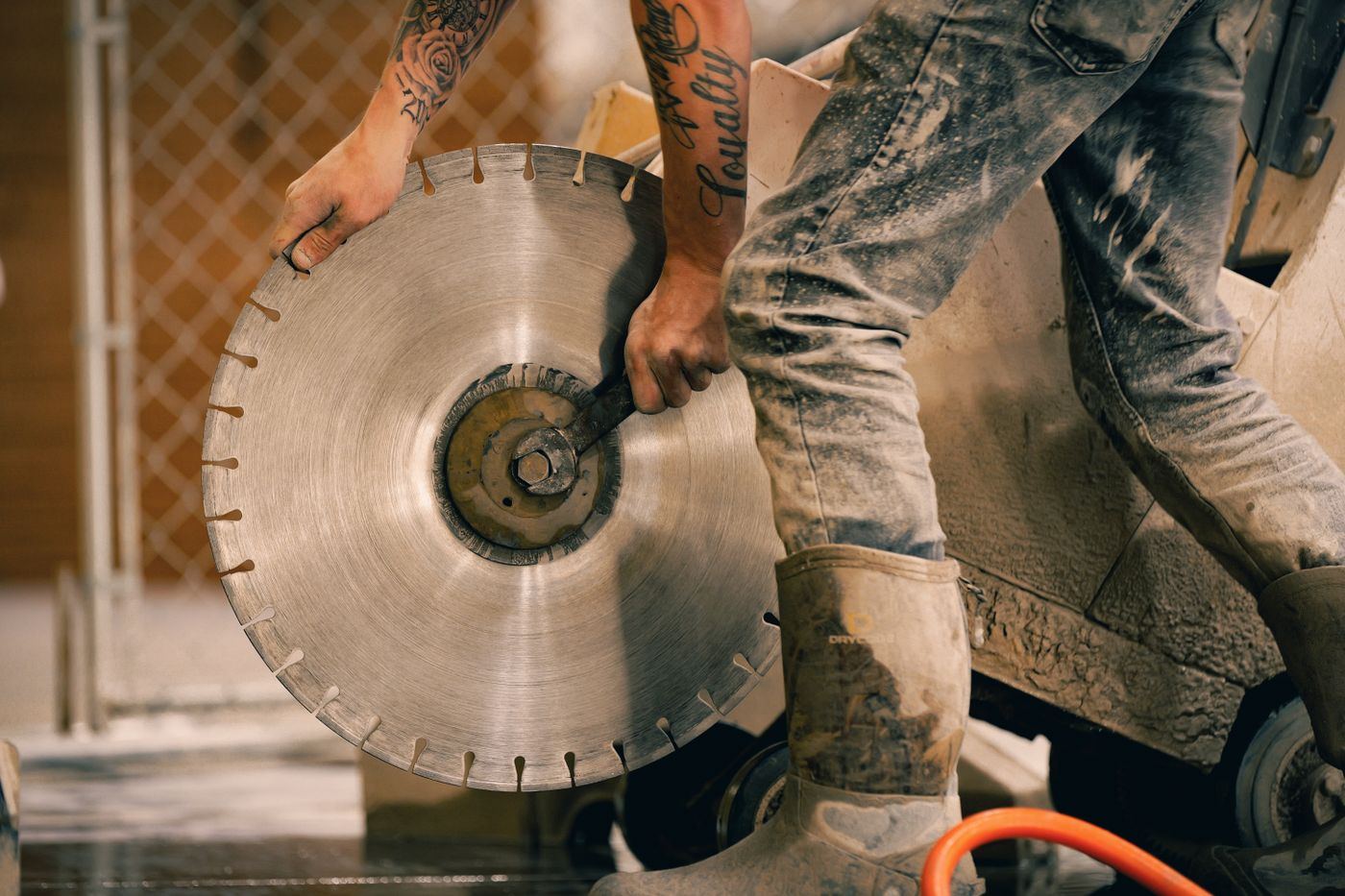 Operator fitting a diamond blade to a concrete saw